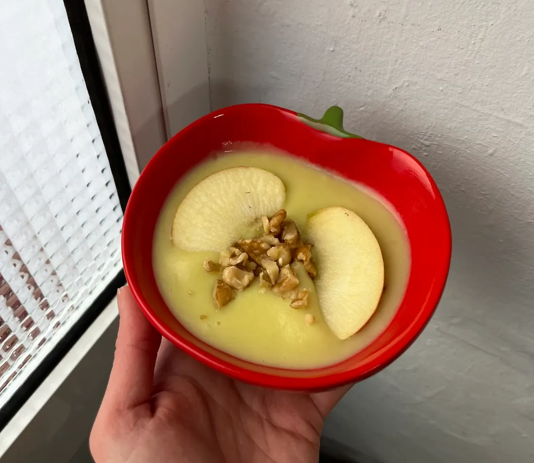 Crema de verduras con manzana y nueces en un cuenco con forma de manzana